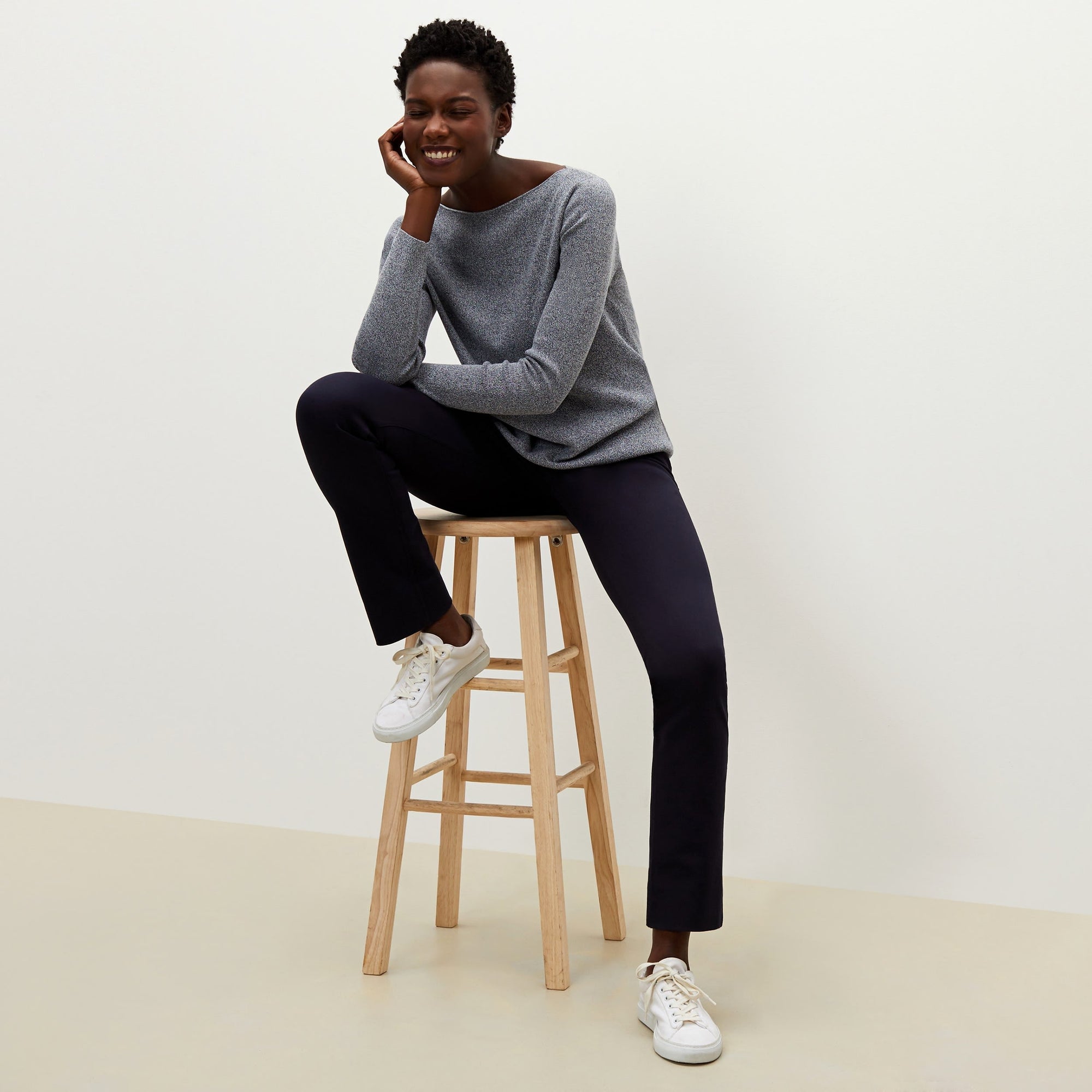 Front image of a woman sitting wearing the Hockley pant in ink | Exclude