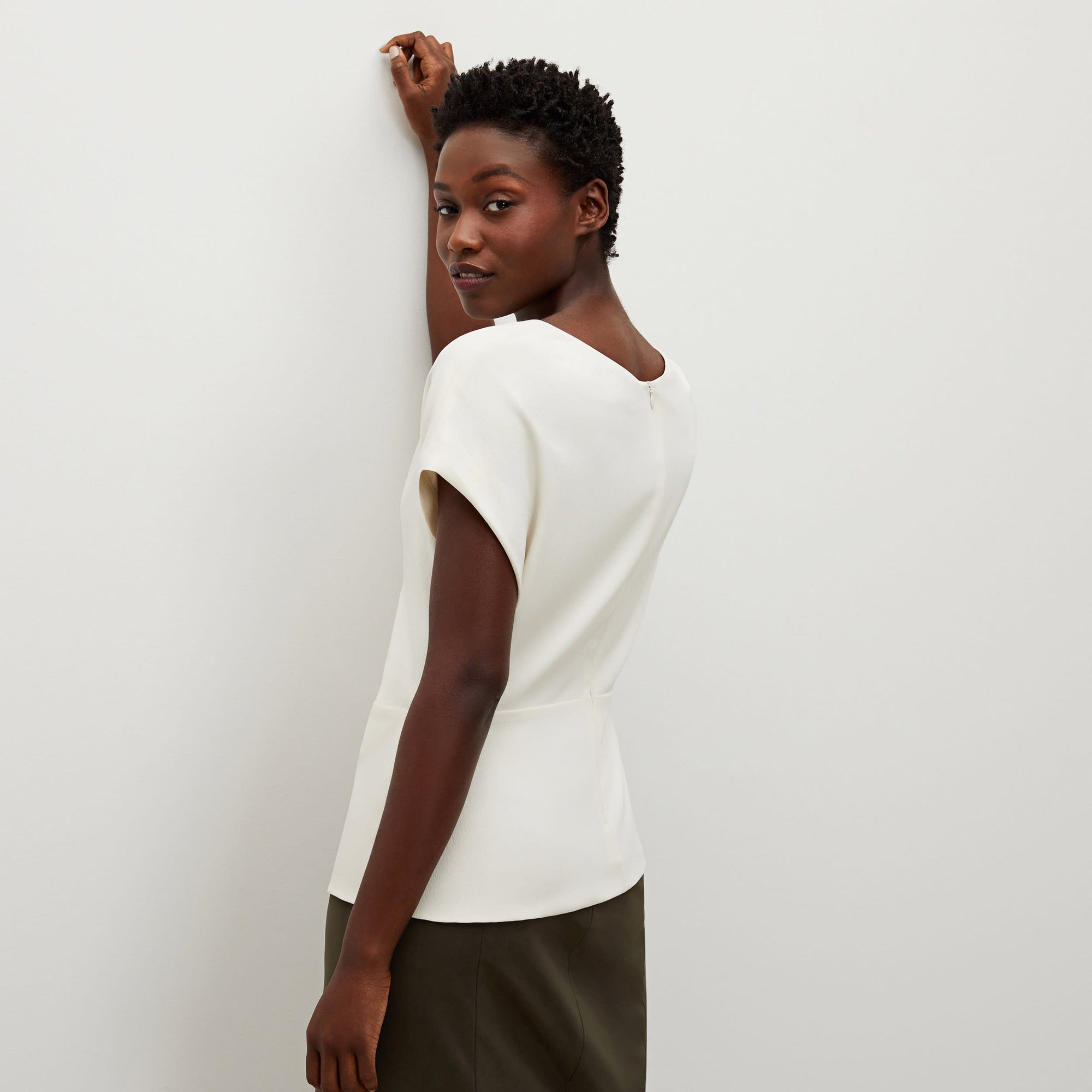 Back image of a woman standing wearing the Nejvi Top in alabaster