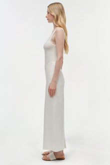 Woman wearing cream cotton cropped pants with a sleeveless top, shown in side profile.
