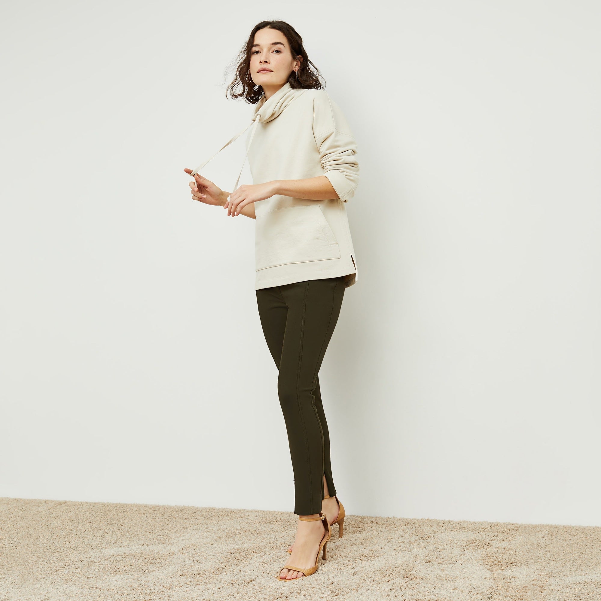 Side image of a woman standing wearing the curie pant in dark olive