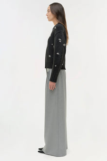 Black knit crewneck sweater with scattered silver embellishments, paired with a gray maxi skirt.