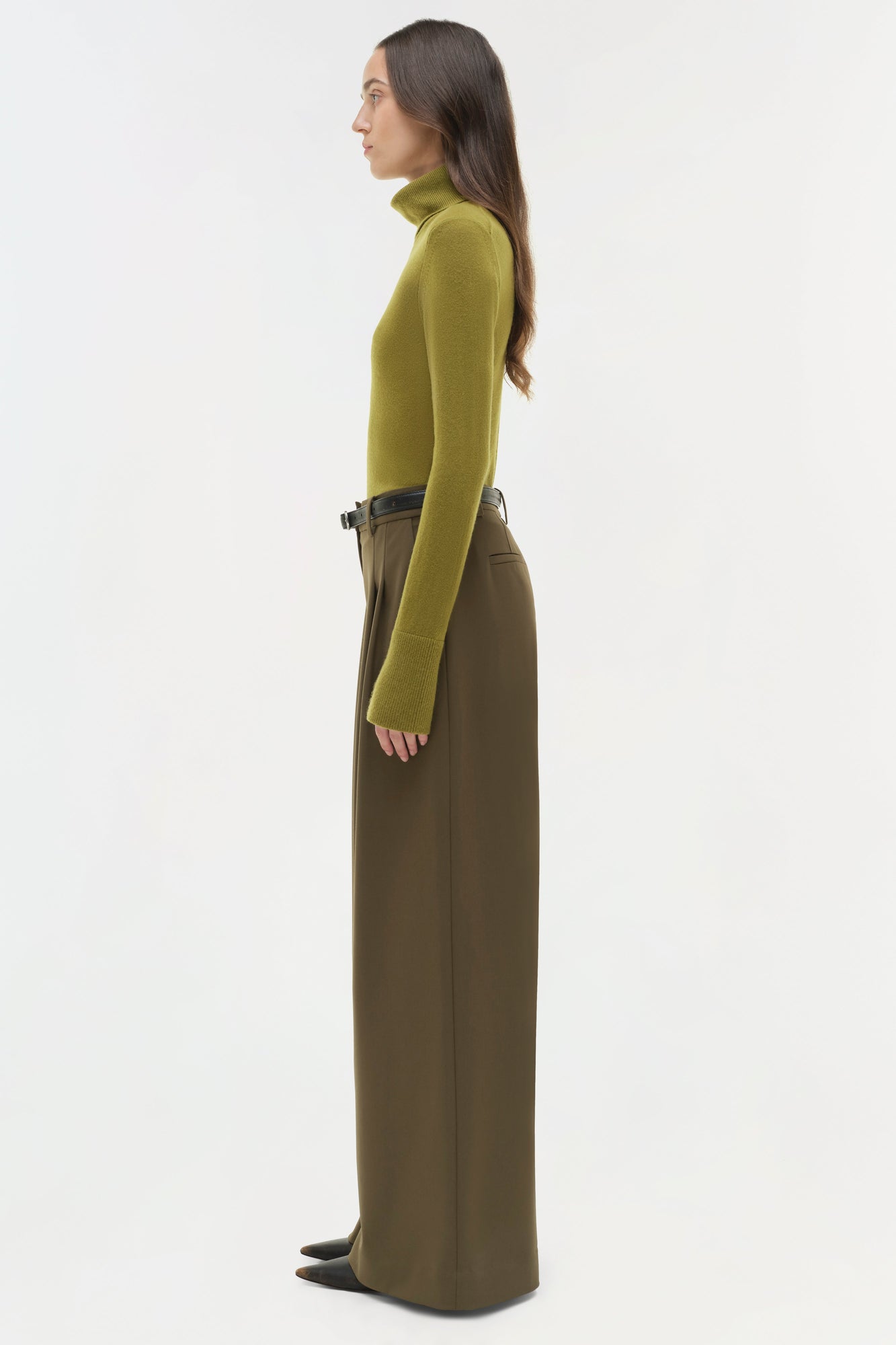Olive-brown wide-leg pant with belt detail worn with yellow-green turtleneck, side view.