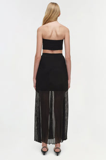 Black knit bandeau bralette with ribbed texture, shown from back on model wearing matching pleated skirt.