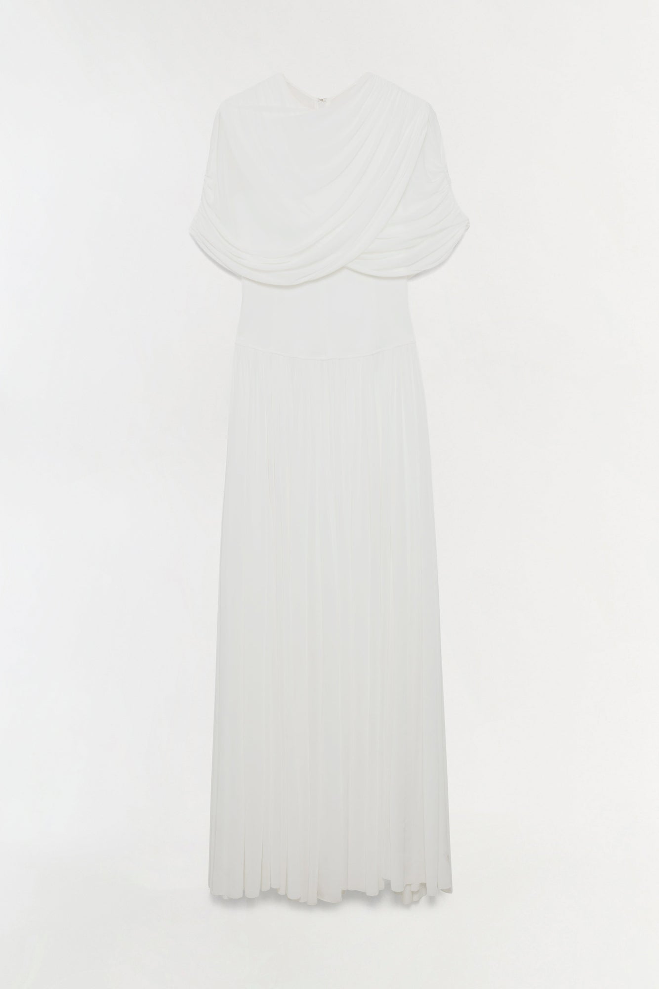 White jersey maxi dress with draped cape overlay and pleated skirt.
