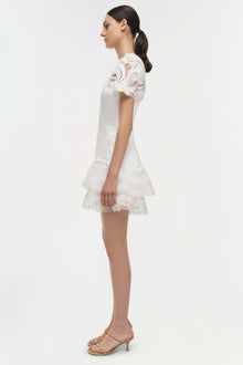 White lace dress with short sleeves, tiered skirt, and paisley pattern throughout.