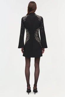 Black mini dress with silver crystal embellishments on shoulders and back, long flared sleeves, worn with dark tights and bla