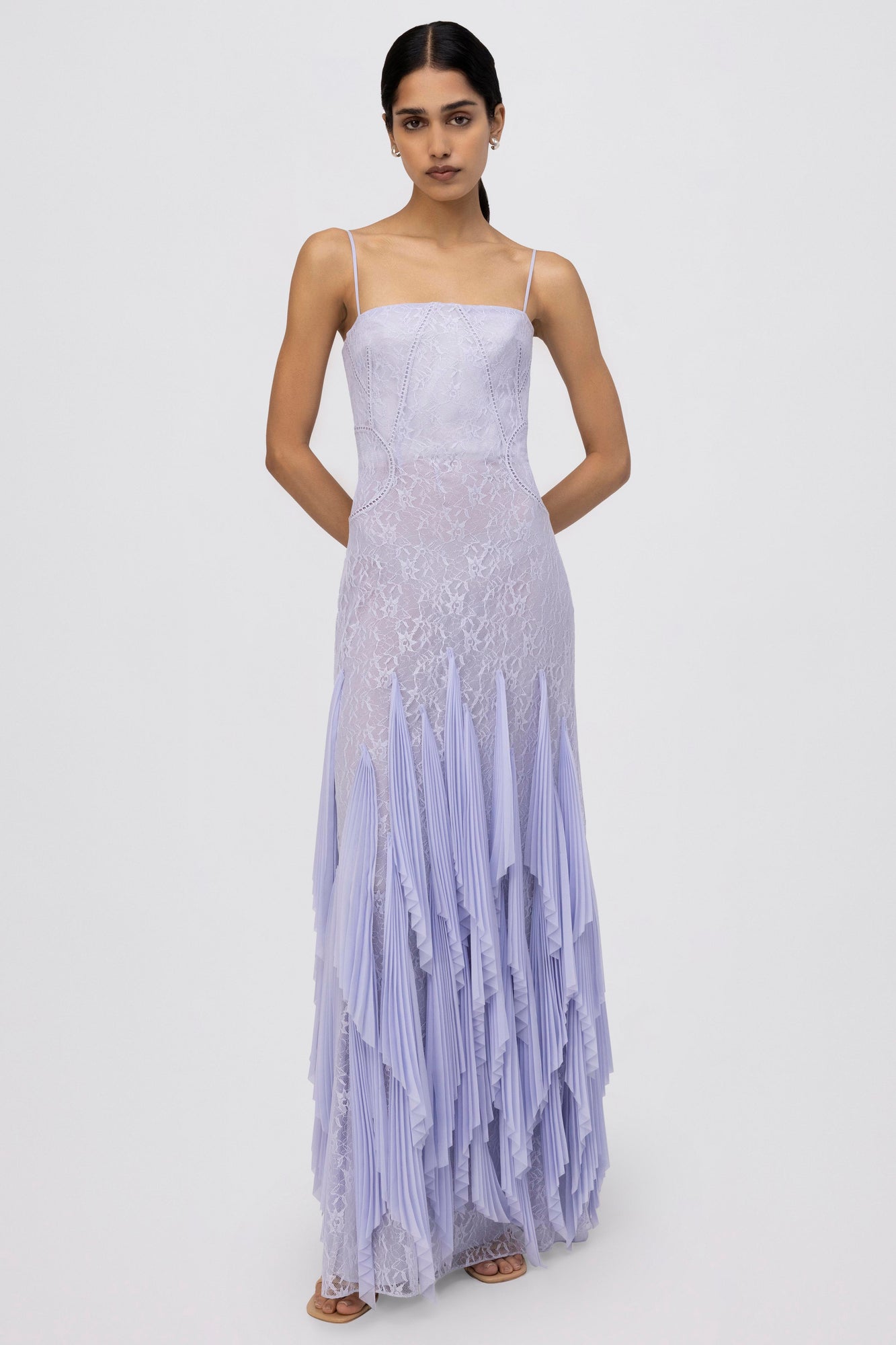 Lavender lace gown with thin straps, fitted bodice, and pleated asymmetrical handkerchief hemline.