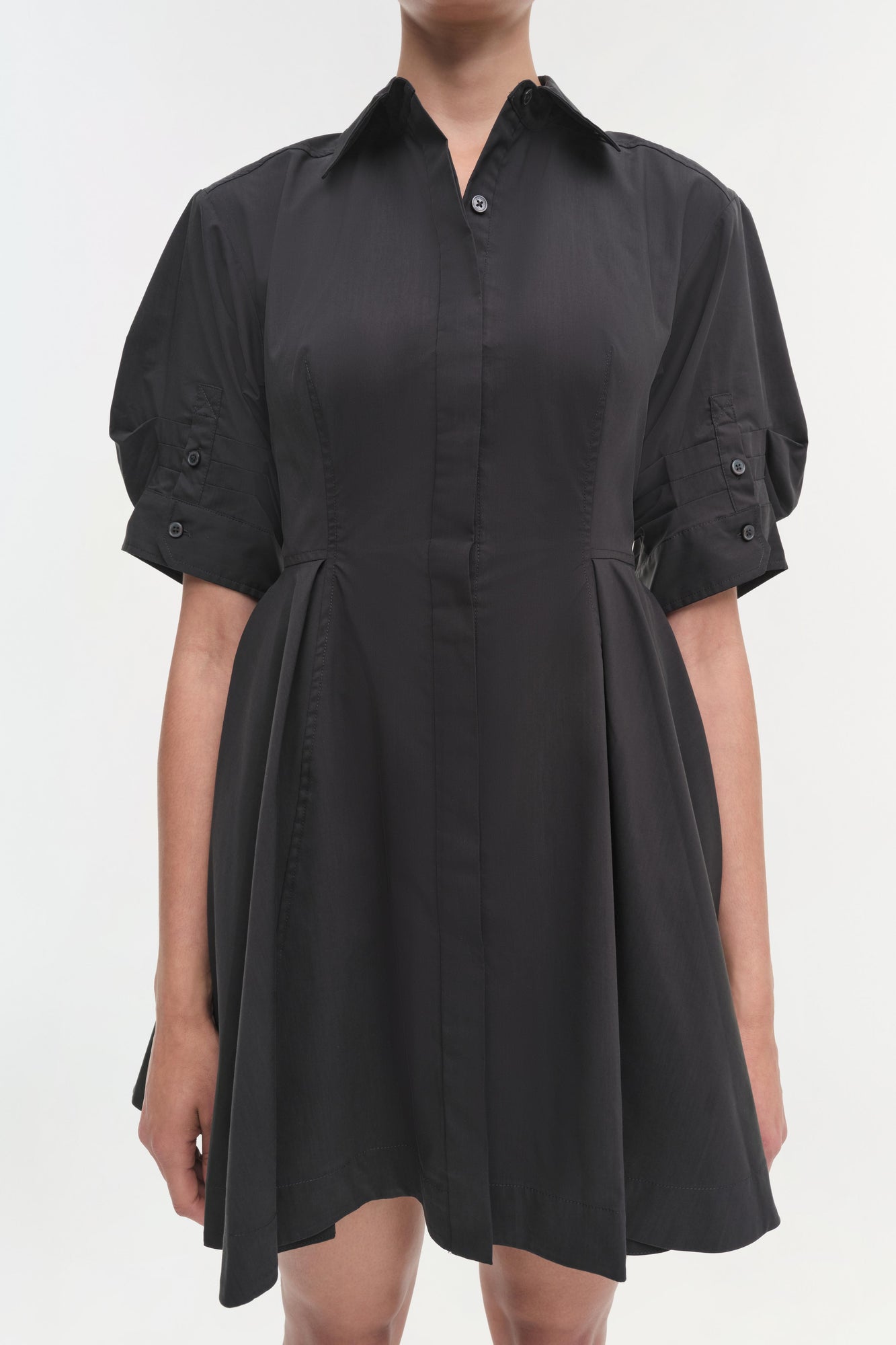 Black button-front shirt dress with puffed sleeves, pleated waist, and knee-length skirt.