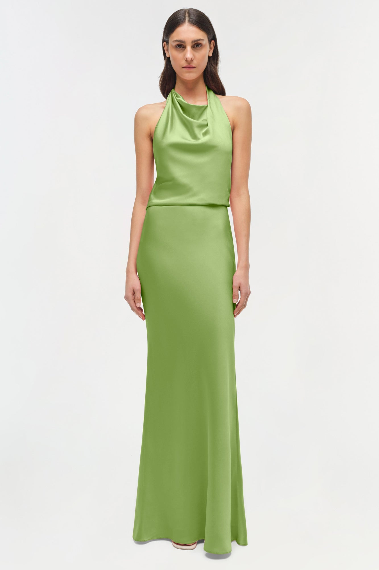 Woman wearing a lime green satin halter gown with draped neckline and fitted silhouette.