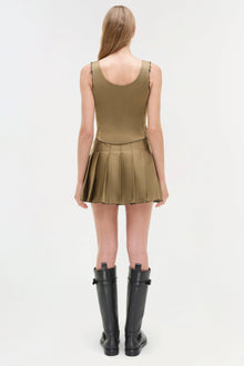 Olive green sleeveless bustier top with pleated skirt bottom, shown with black knee-high boots.