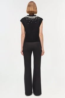 Black sleeveless knit vest with crystal embellishments across the shoulders and neckline.
