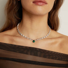 Model. Necklace with a green gemstone worn by a person