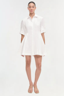 White button-front shirt dress with three-quarter sleeves and a-line skirt, shown on model wearing tan sandals.