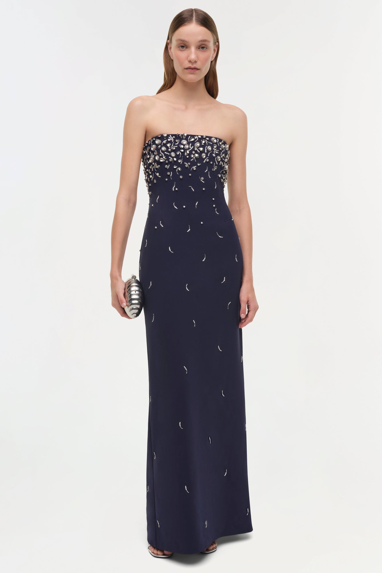 Navy strapless gown with silver beaded embellishments concentrated at bodice, flowing down skirt.