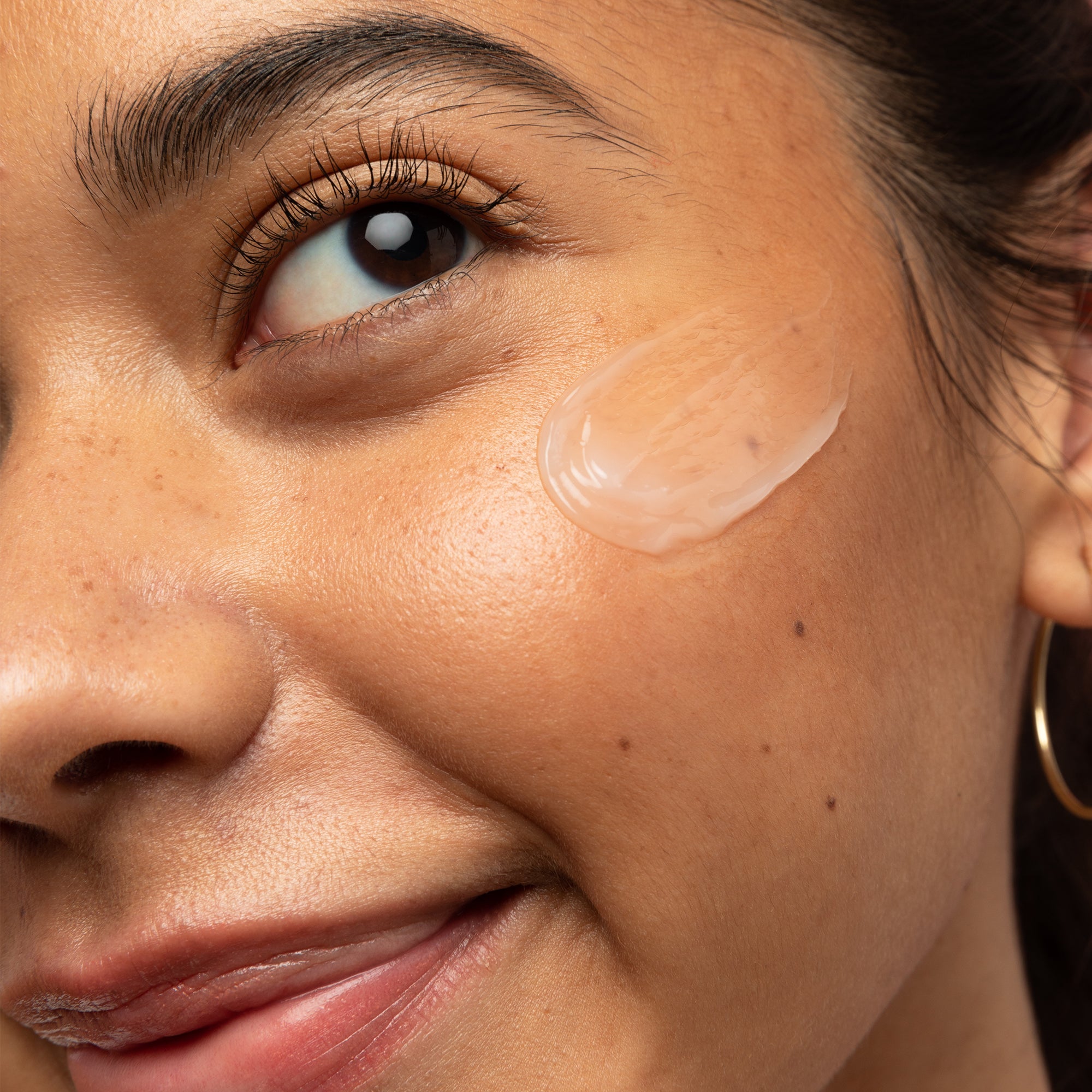 Model with swatch of Coconut Water Cream on her cheek.