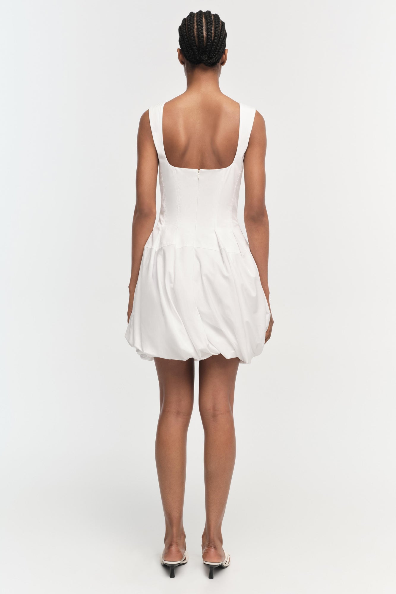 White sleeveless mini dress with square neckline and gathered bubble skirt, shown from back view.
