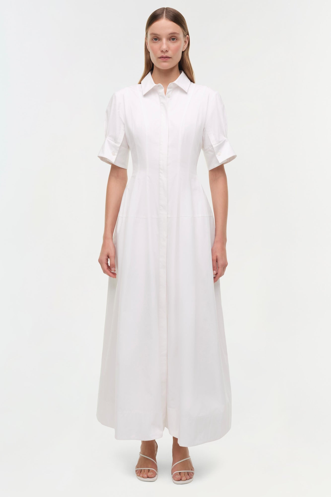 White cotton shirt dress with short sleeves, collar, button front, and ankle-length A-line skirt on model.