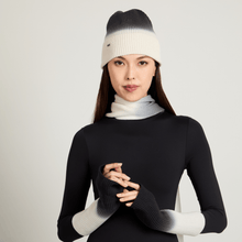 Model wearing a black and white ombre beanie, scarf, and gloves on a light gray background