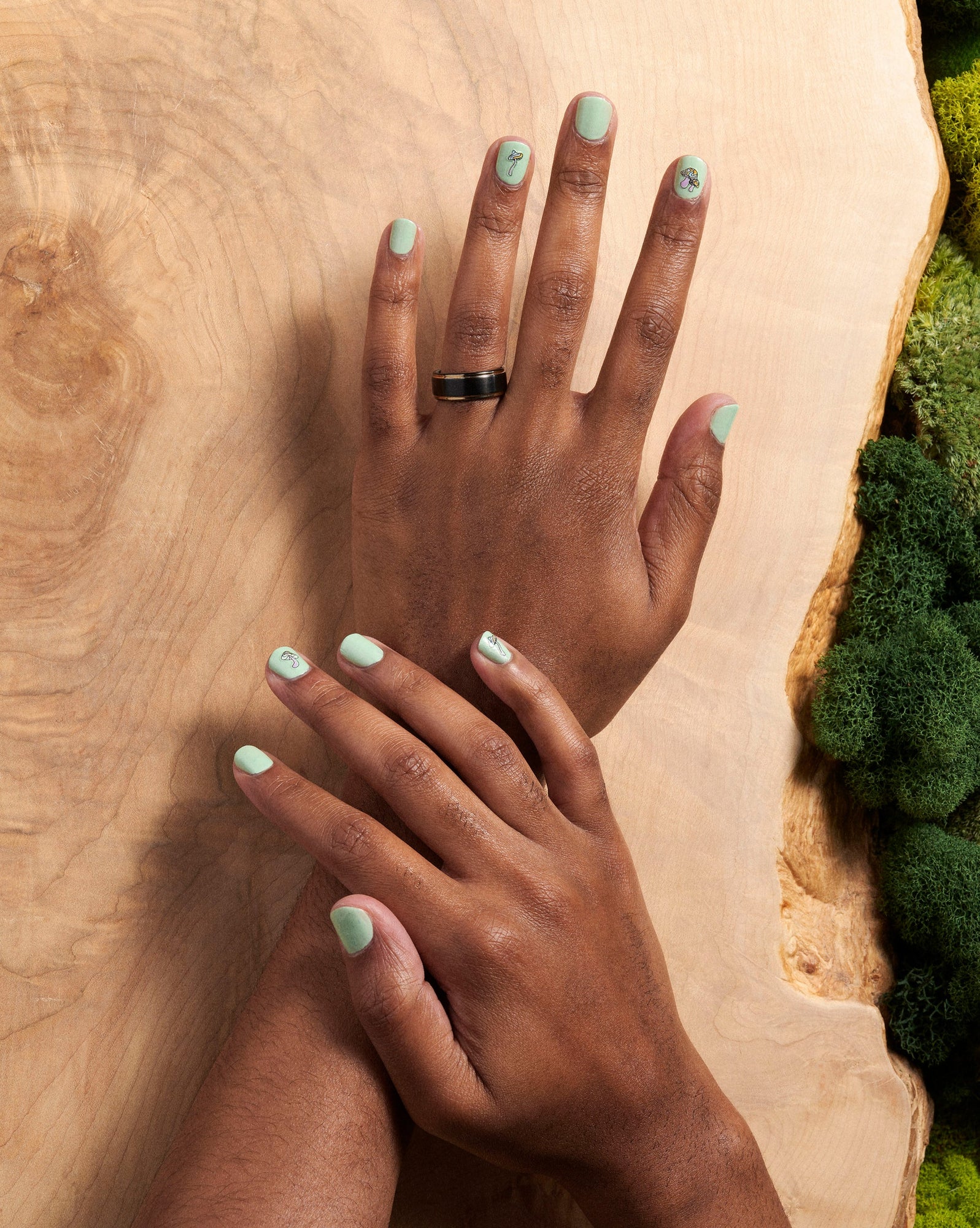 An overhead view of hands wearing the sprouting polish