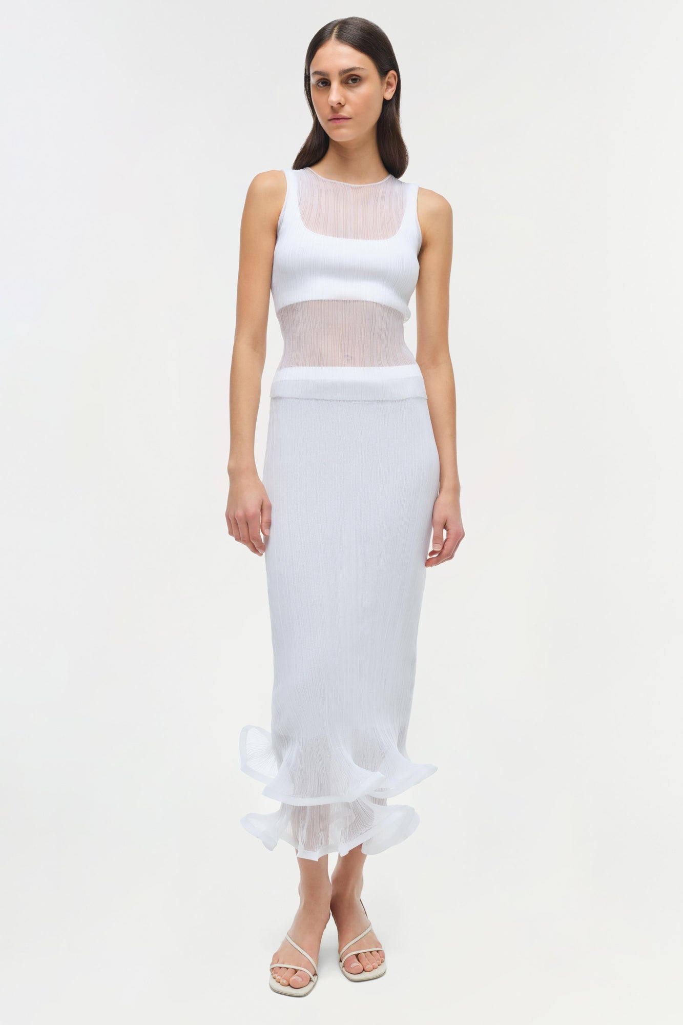 Woman wearing white ribbed sleeveless tank top with sheer mesh panels at chest and waist.