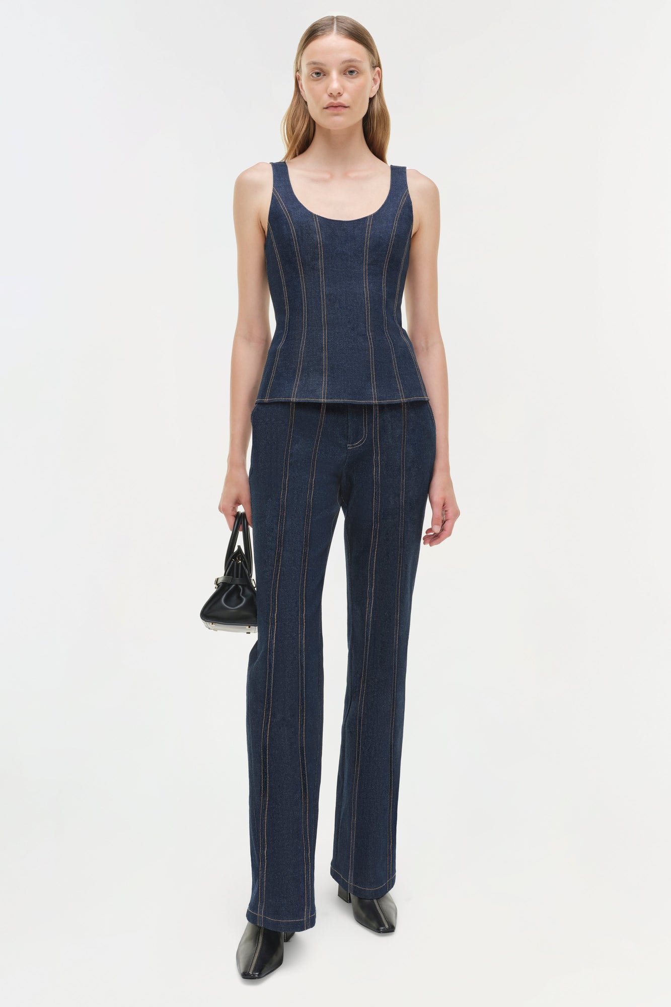 Dark blue denim sleeveless bustier top with vertical seam details, paired with matching flared denim pants.