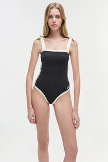 Black and white colorblocked one-piece swimsuit with square neckline and contrast side panels.