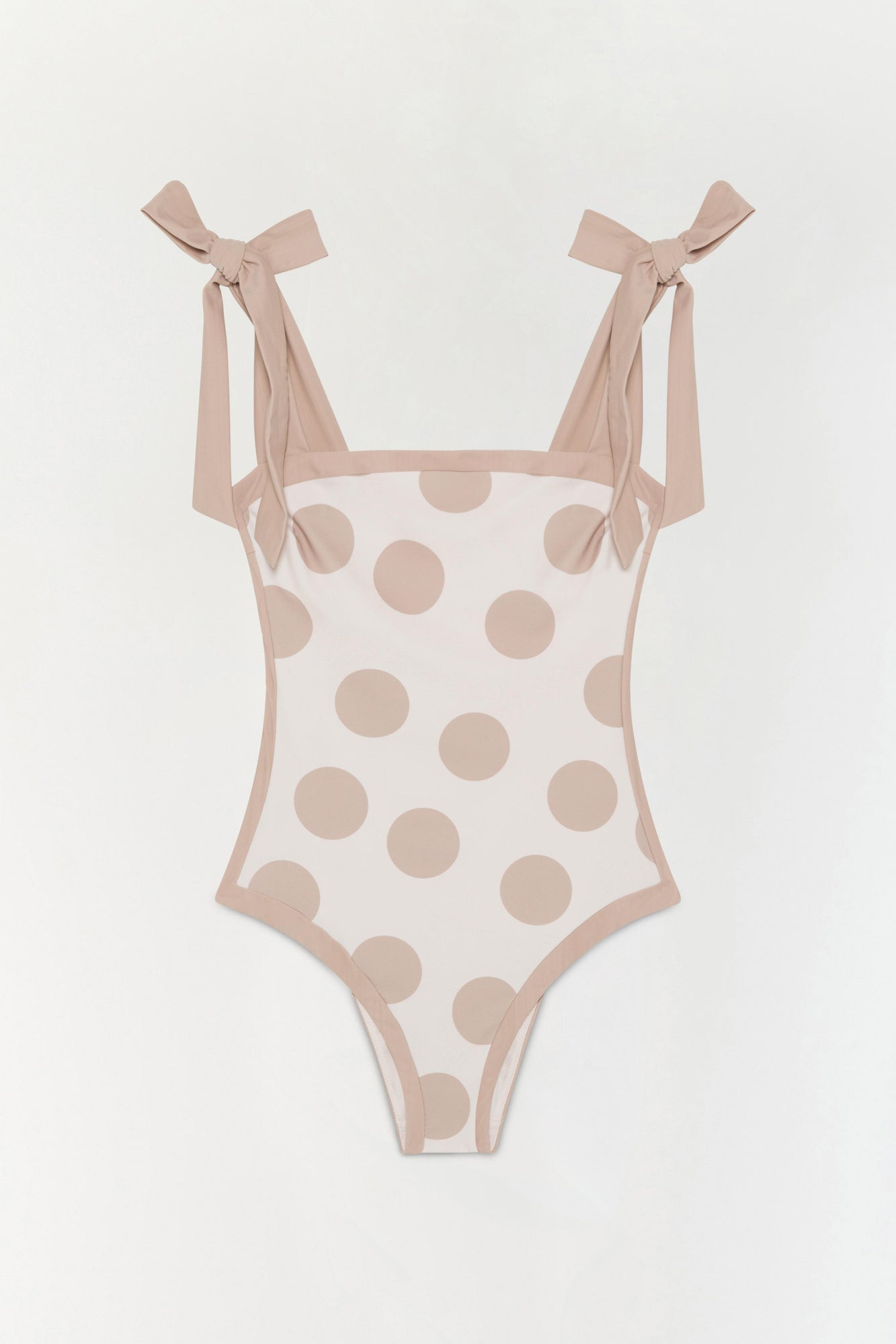 Beige one-piece swimsuit with tan polka dots and tied shoulder straps.