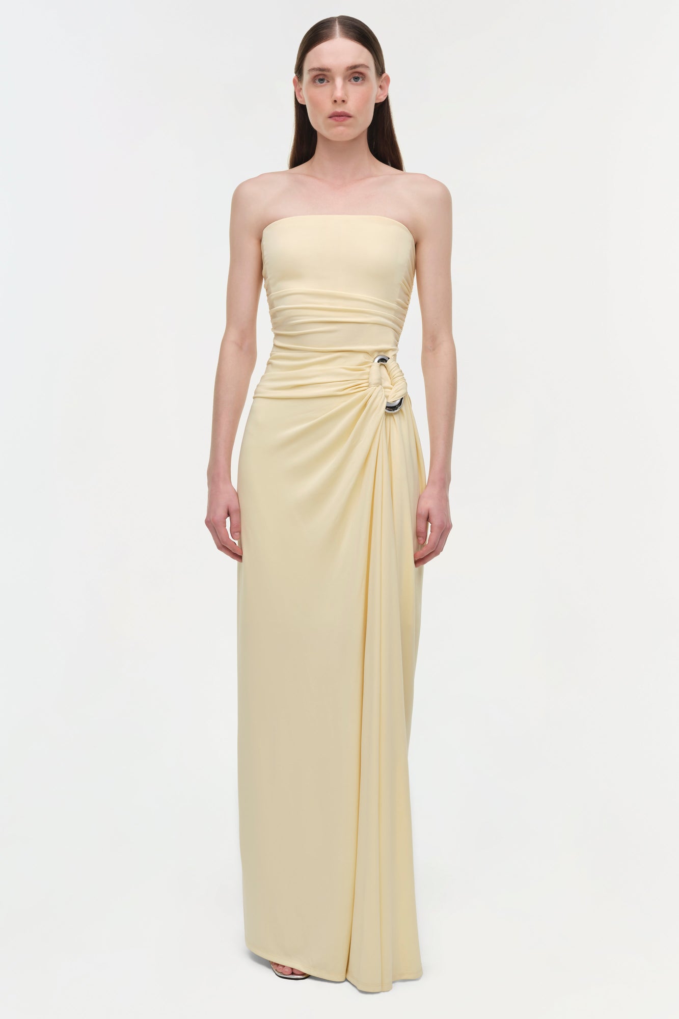 Cream strapless floor-length gown with draped bustier bodice and gathered waist detail with buckle accent.