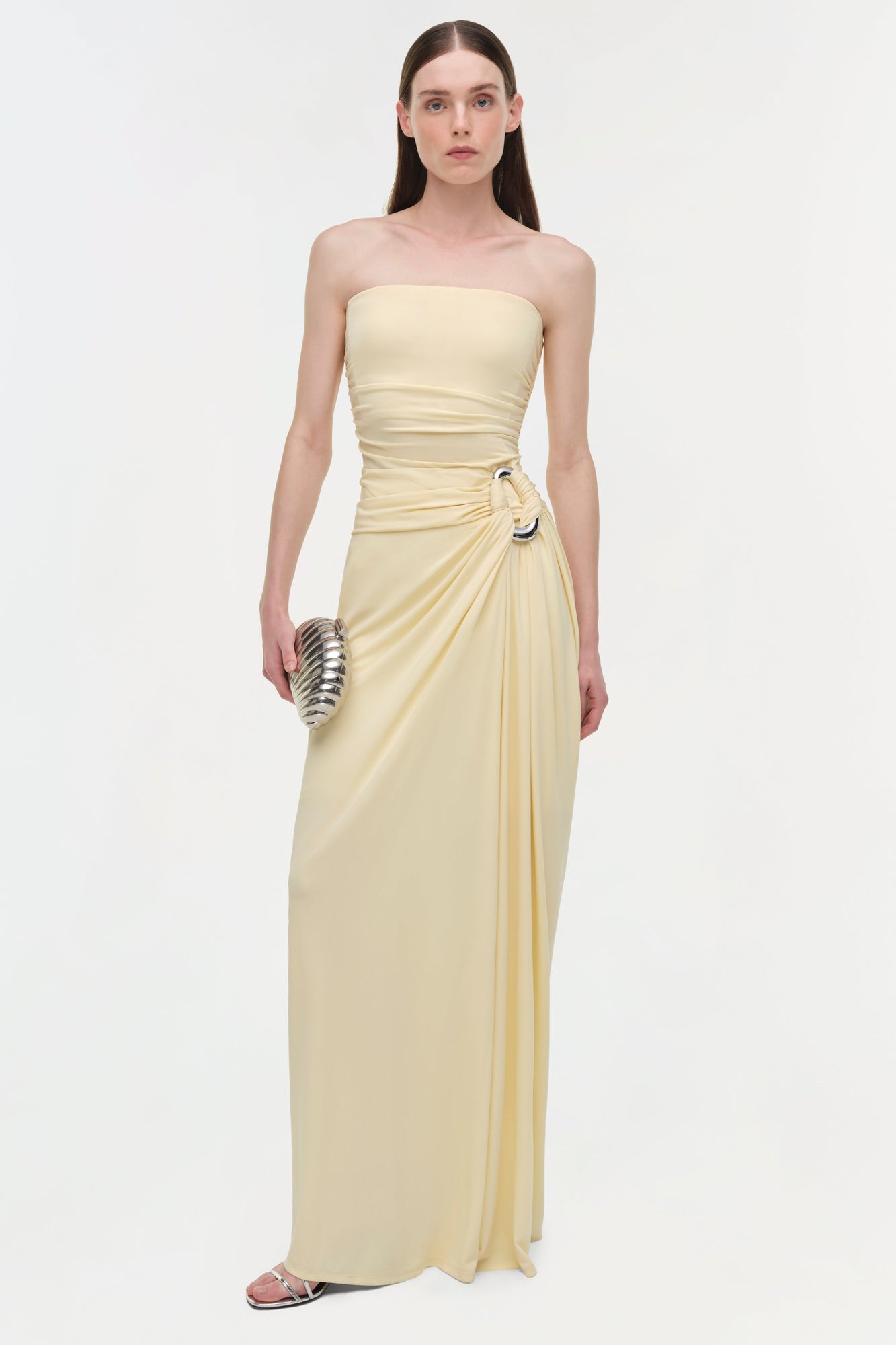 Cream strapless draped gown with ruched waist detail and side buckle accent.