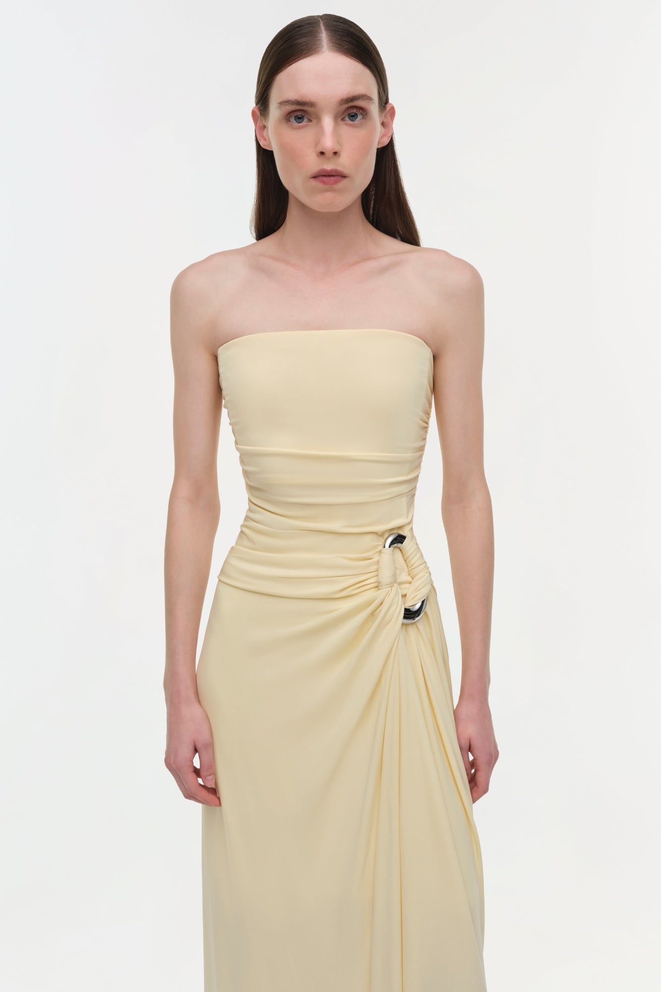 Cream strapless gown with draped ruching at the bodice and gathered side detail with decorative hardware.
