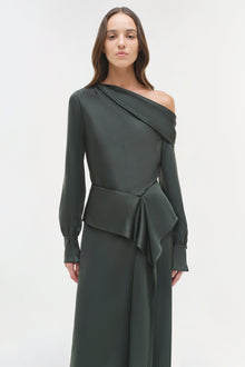Woman wearing a charcoal satin midi skirt with asymmetrical draped top and long sleeves.