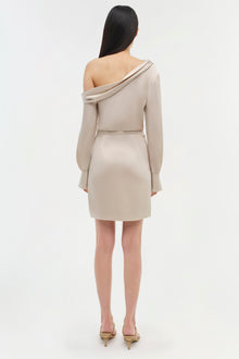 Beige off-shoulder dress with long sleeves and fitted silhouette, shown from back view on model.