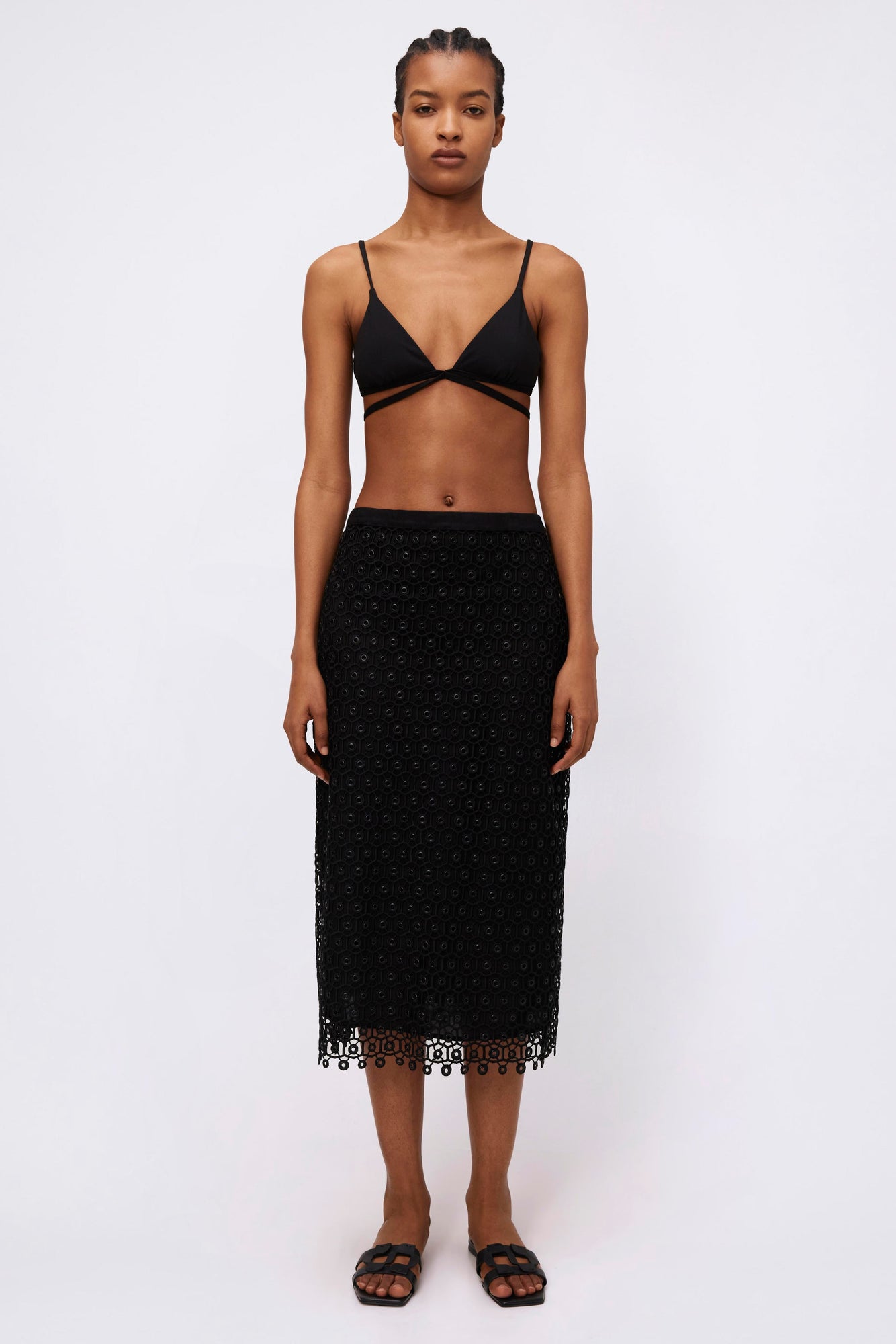 Black textured midi skirt with geometric lace pattern and scalloped hem.