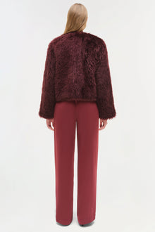 Burgundy shearling jacket with fuzzy texture and cropped fit, shown from back on model wearing matching pants.