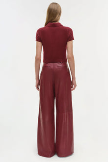 Burgundy leather wide-leg pants with high waist and front pocket details, shown from back view.