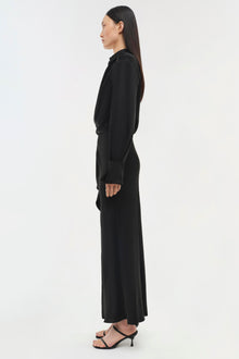 Black long-sleeve maxi dress with a collared neckline and fitted waist, shown on a model from the side profile.
