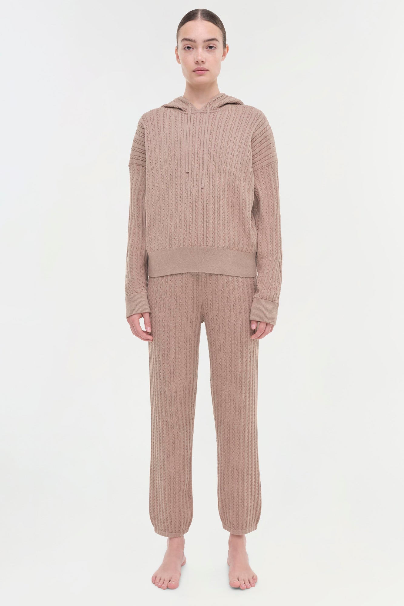 Beige cable knit hoodie and matching jogger pants on model shown front view.