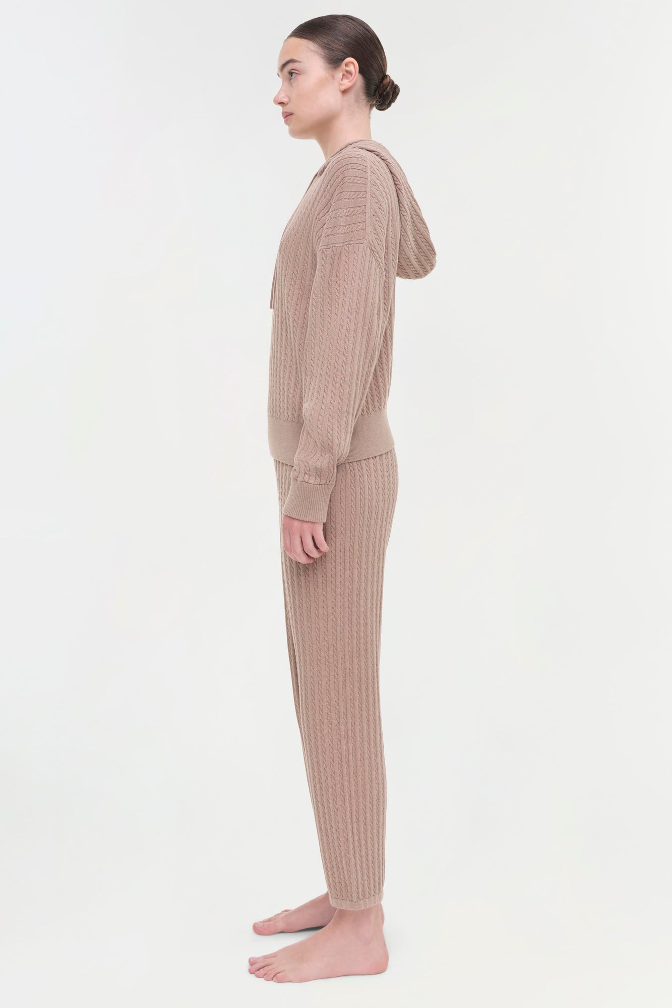 Beige cable knit hoodie and matching pants on model shown from the side.