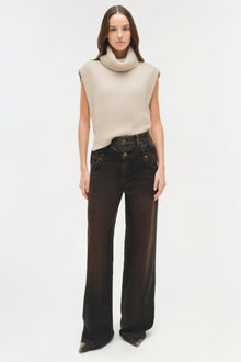 Cream ribbed sleeveless turtleneck top with vertical texture pattern paired with dark denim jeans.