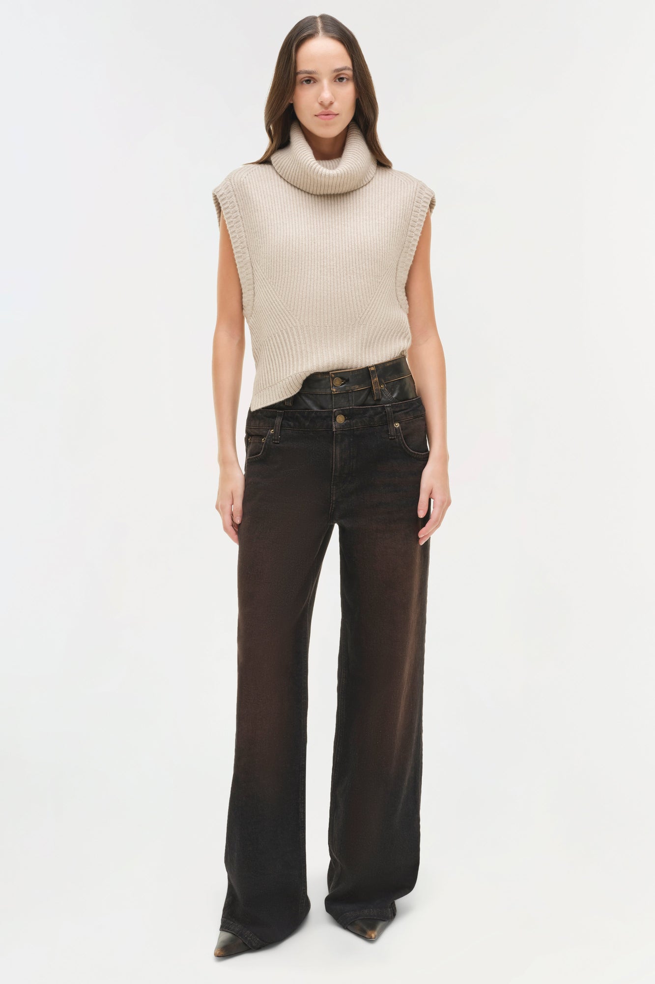 Cream ribbed sleeveless turtleneck top with vertical texture pattern paired with dark denim jeans.