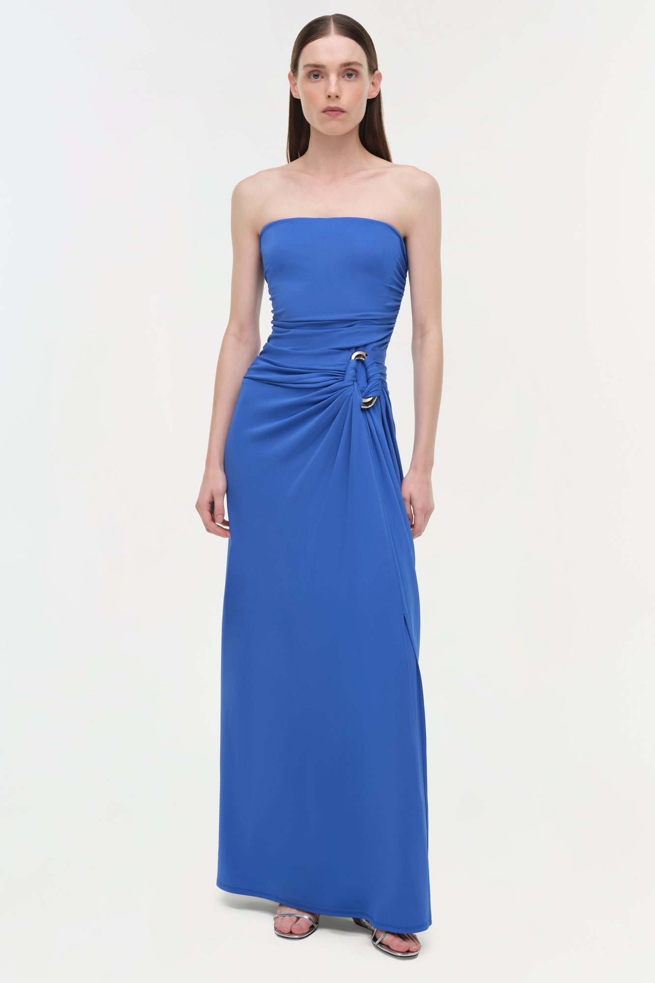 Blue strapless floor-length gown with draped side detail and gold embellishment at waist.