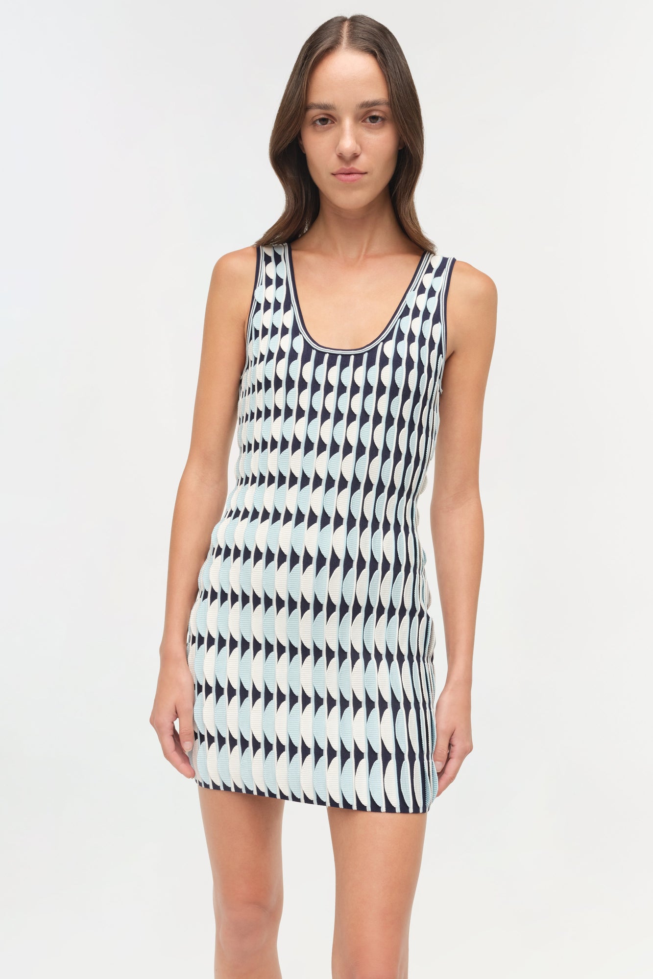 Sleeveless knit mini dress in cream and navy with geometric triangle pattern and scalloped edges.