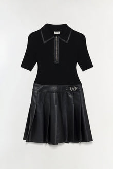 Black mini dress with ribbed knit polo top, leather trim collar, zip placket, and pleated faux leather skirt with belt detail