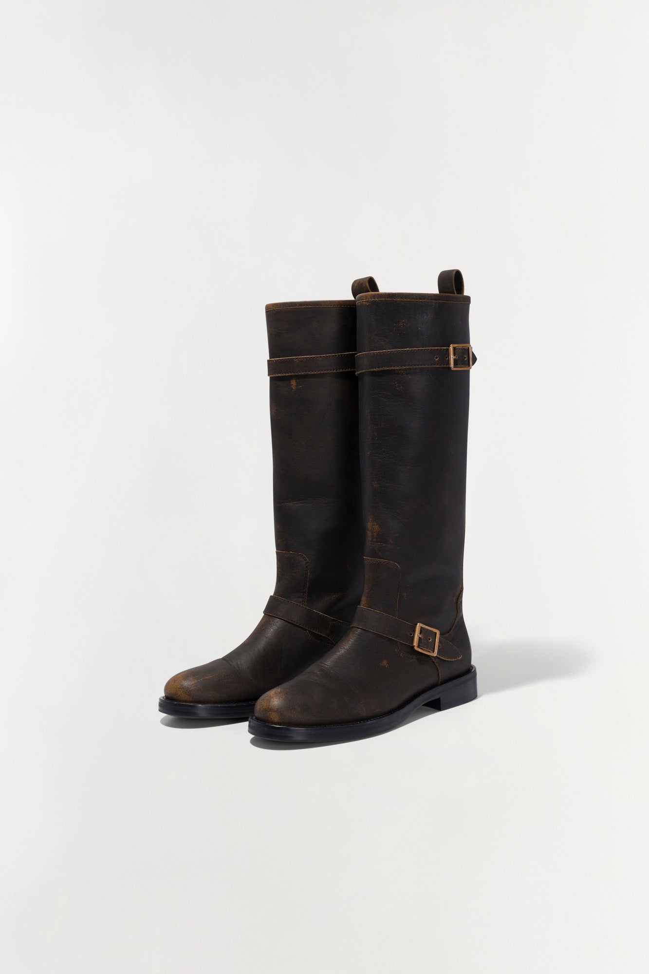 Black leather motorcycle boots with buckle straps and distressed finish, shown from the front.