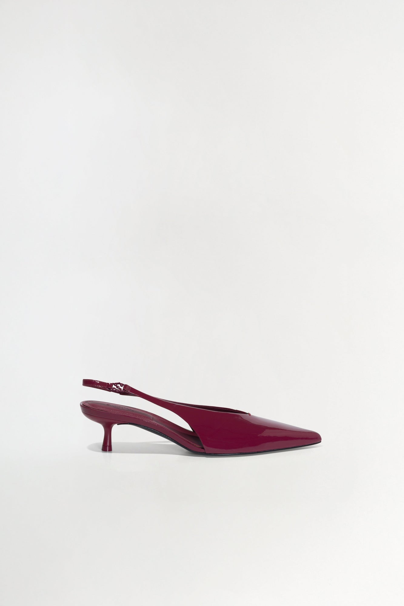 Burgundy patent leather slingback heel with pointed toe and thin kitten heel.