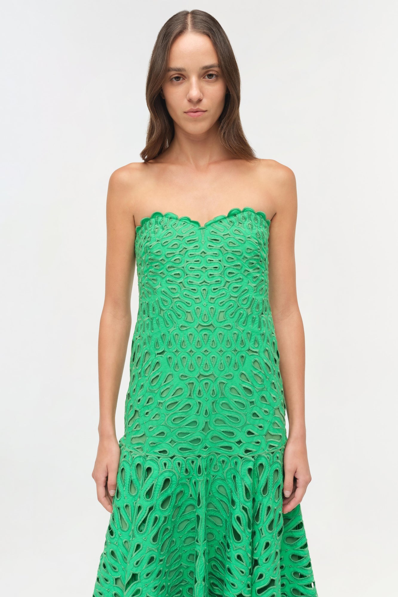 Green strapless midi dress with allover cutout embroidered pattern and scalloped neckline.
