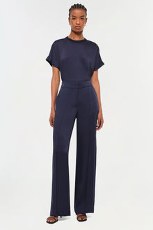 Woman wearing a navy short-sleeve t-shirt with a round neckline and navy wide-leg trousers.