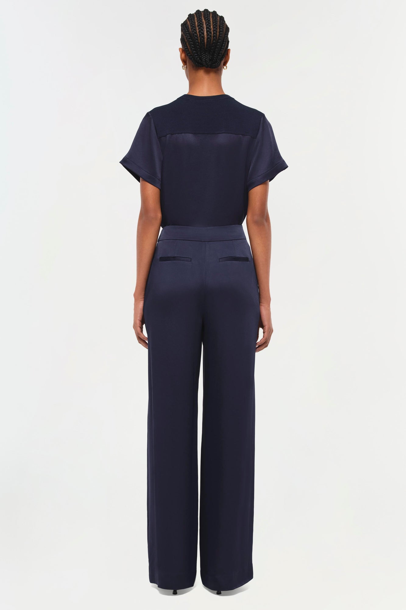 Back view of a person wearing a dark navy short-sleeve t-shirt with matching wide-leg trousers.