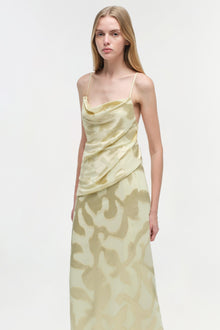 Cream-colored sleeveless gown with cowl neckline and draped bodice, featuring abstract patterned skirt.