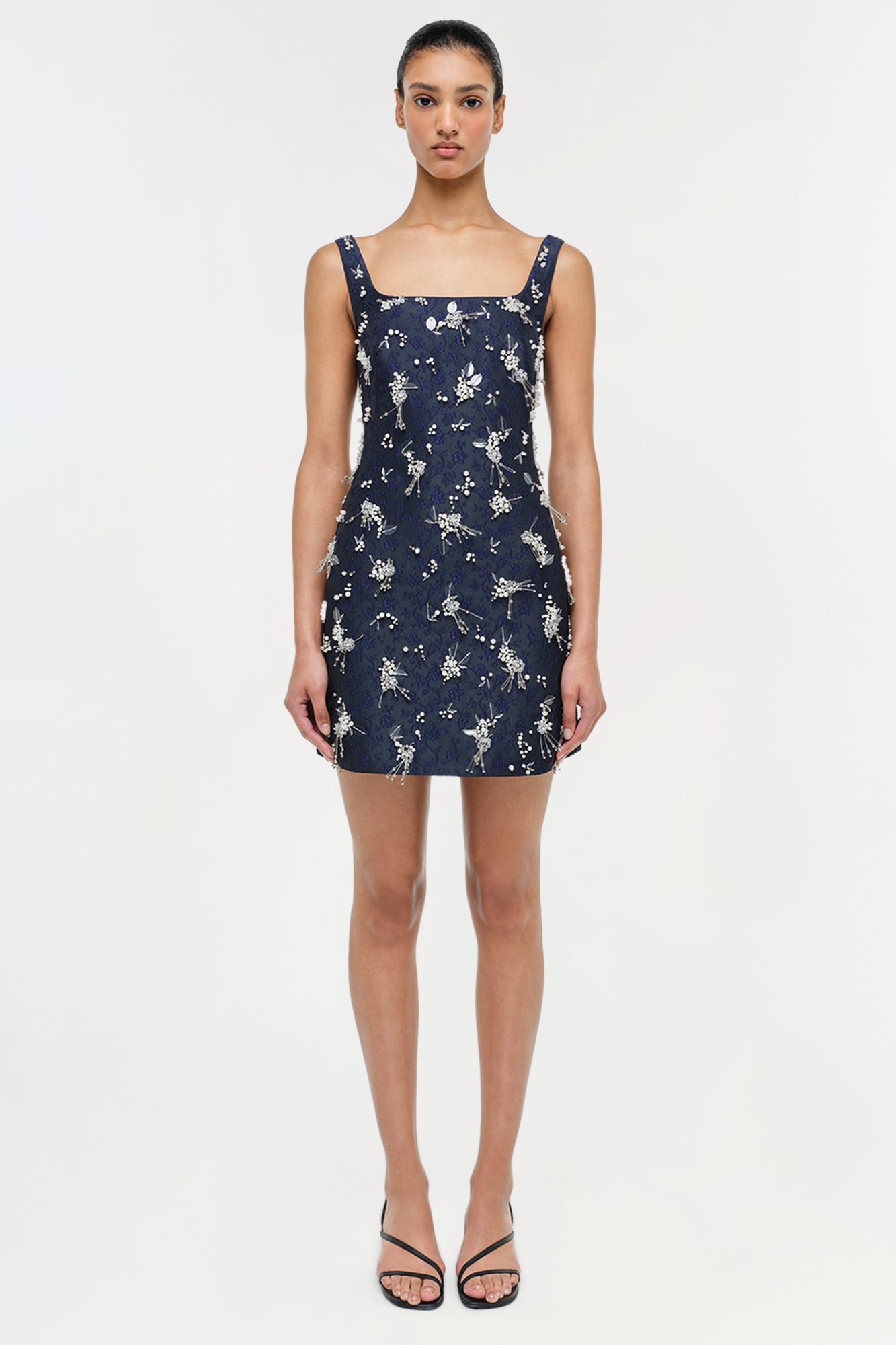 Navy mini dress with white floral jacquard pattern and square neckline, displayed on model.